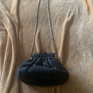 Textured black tote with gold snap closure and chain.